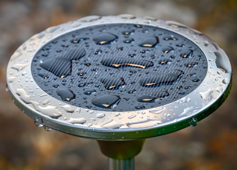 A solar-powered device with a micro inverter covered with raindrops.