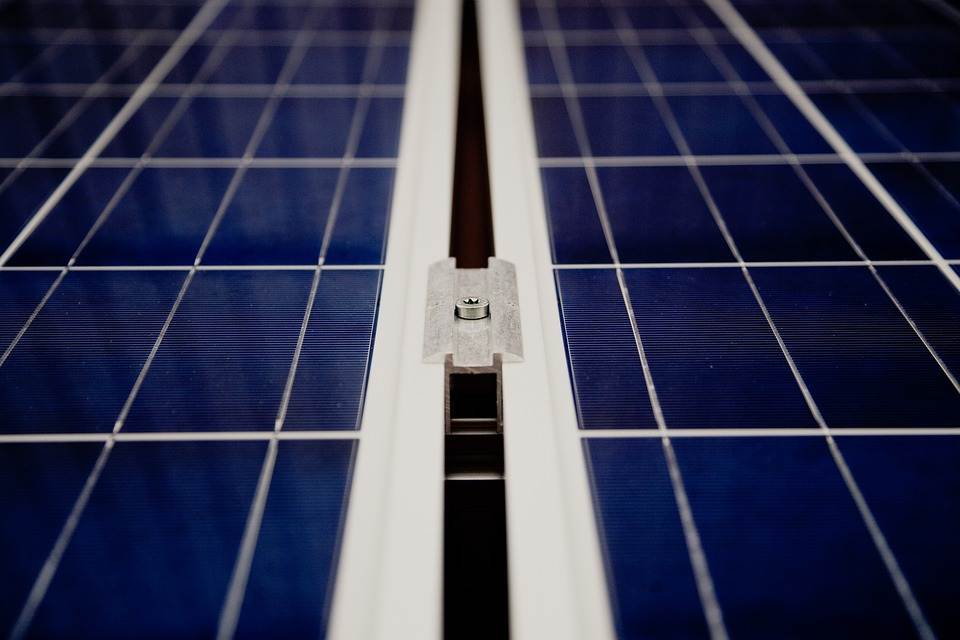 Close-up of a solar panel array with a focus on the mounting system and the cells' grid layout, featuring an integrated Micro Inverter.