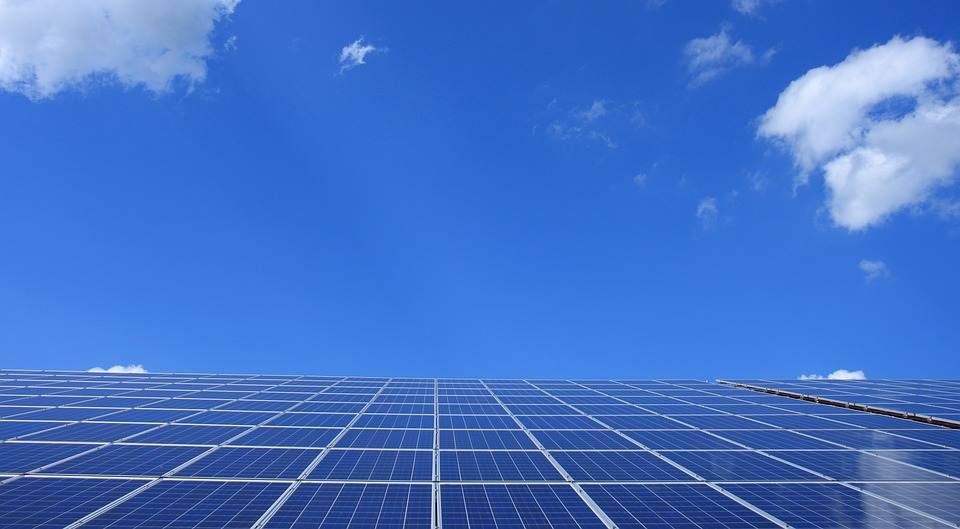 Solar panels equipped with a Micro Inverter, against a backdrop of a clear blue sky with a few clouds.